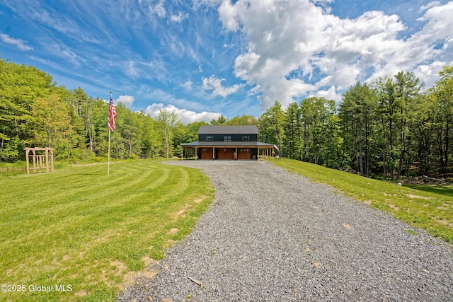 17 Ringwald Rd, Coeymans, NY 12046 - view of front of home featuring gravel driveway, a garage, a front lawn, and a wooded view