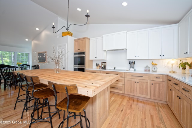 17 Ringwald Rd, Coeymans, NY 12046 - kitchen with double oven, light brown cabinetry, a kitchen bar, light wood-style floors, and recessed lighting
