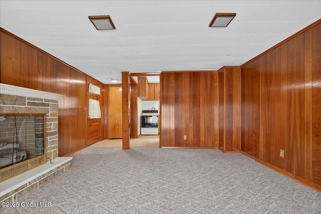 149 Wilton Rd, Greenfield, NY 12833 - unfurnished living room featuring wooden walls, a fireplace with raised hearth, and carpet