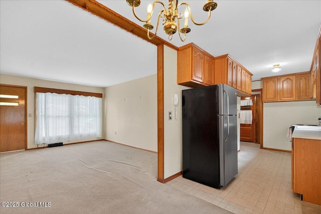 149 Wilton Rd, Greenfield, NY 12833 - kitchen with freestanding refrigerator, a chandelier, baseboards, and brown cabinets
