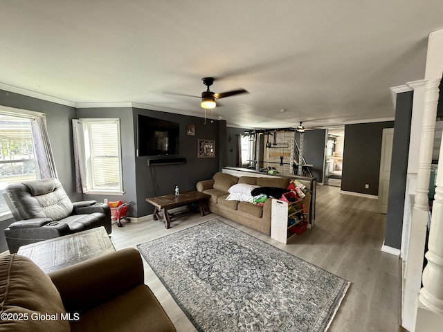 243 N Perry St, Johnstown, NY 12095 - living room featuring ceiling fan, baseboards, crown molding, wood finished floors, and decorative columns