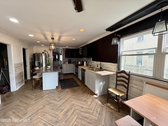 243 N Perry St, Johnstown, NY 12095 - kitchen with a sink, appliances with stainless steel finishes, a kitchen bar, ornamental molding, and a center island