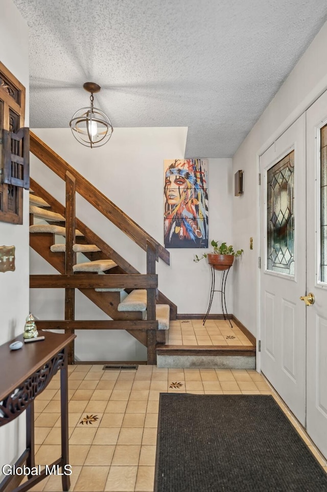 7 Hawthorn Cir, Albany, NY 12203 - foyer with tile patterned flooring, stairway, and a textured ceiling