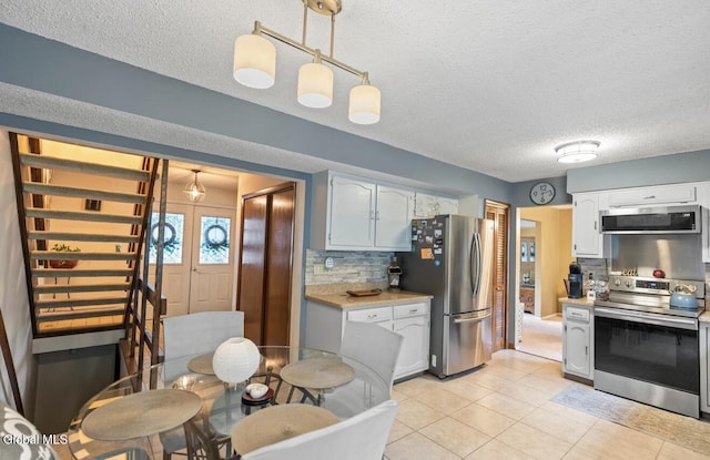 7 Hawthorn Cir, Albany, NY 12203 - kitchen featuring appliances with stainless steel finishes, light countertops, tasteful backsplash, a textured ceiling, and light tile patterned floors