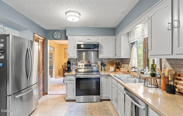 7 Hawthorn Cir, Albany, NY 12203 - kitchen featuring appliances with stainless steel finishes, light countertops, tasteful backsplash, light tile patterned flooring, and a textured ceiling