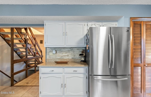 7 Hawthorn Cir, Albany, NY 12203 - kitchen with freestanding refrigerator, white cabinetry, decorative backsplash, light countertops, and light tile patterned flooring