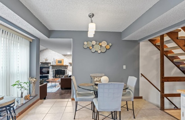 7 Hawthorn Cir, Albany, NY 12203 - tiled dining area with a brick fireplace, stairs, and a textured ceiling