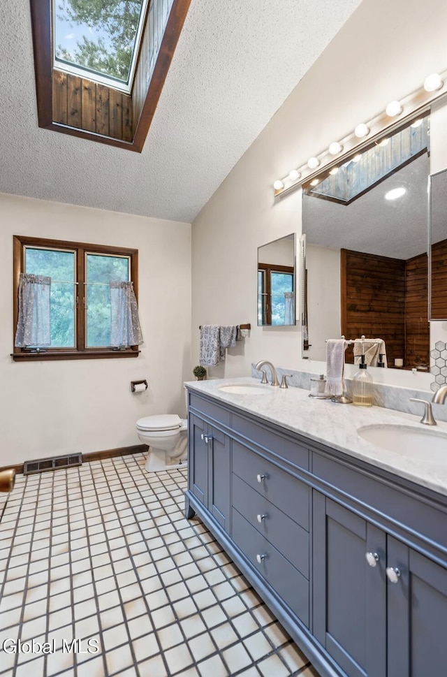 7 Hawthorn Cir, Albany, NY 12203 - bathroom with a skylight, double vanity, and a textured ceiling