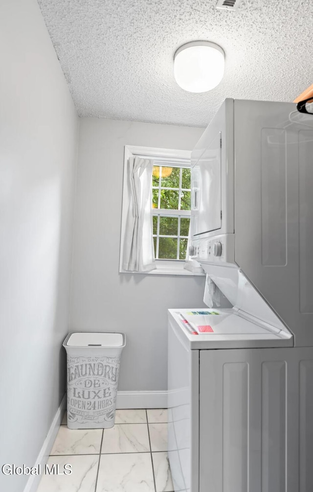 7 Hawthorn Cir, Albany, NY 12203 - laundry room featuring stacked washer / drying machine, light marble finish flooring, and a textured ceiling
