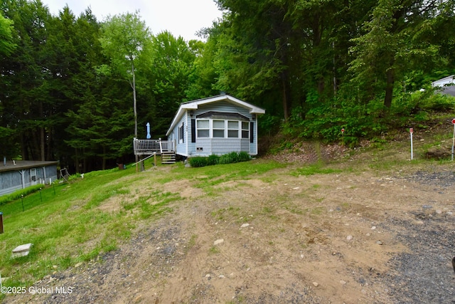 202 Lakeland Rd, Edinburg, NY 12835 - view of front of home with a view of trees and a deck