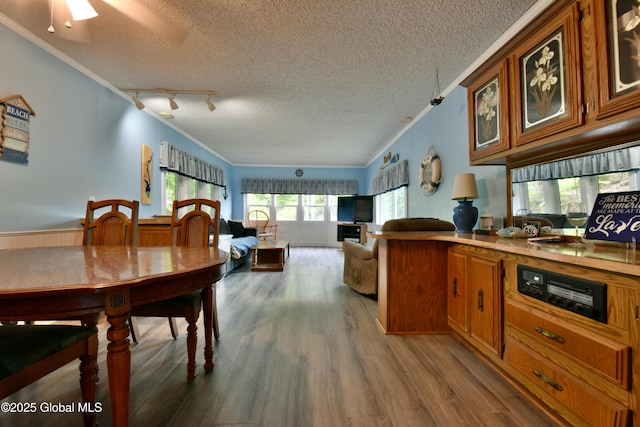 202 Lakeland Rd, Edinburg, NY 12835 - kitchen with brown cabinets, wood finished floors, ornamental molding, a textured ceiling, and track lighting