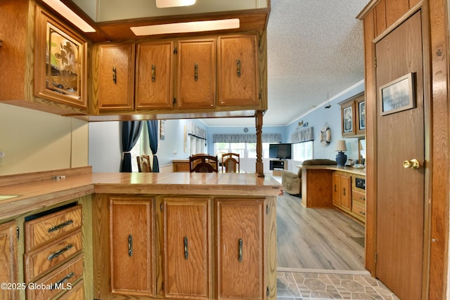 202 Lakeland Rd, Edinburg, NY 12835 - kitchen featuring brown cabinets, a textured ceiling, open floor plan, a peninsula, and butcher block counters