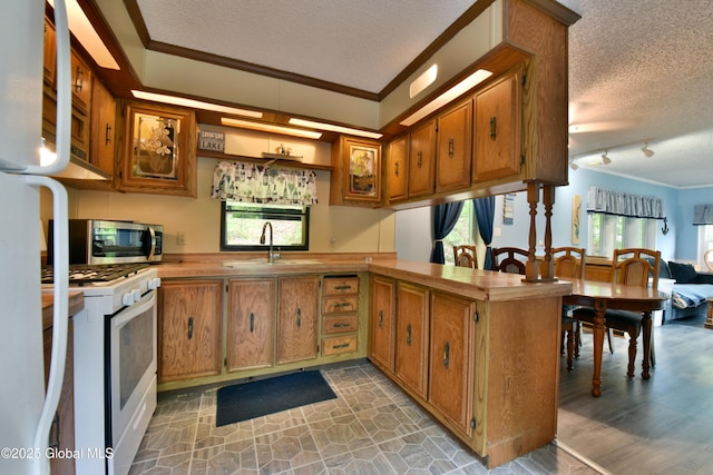 202 Lakeland Rd, Edinburg, NY 12835 - kitchen featuring a textured ceiling, white gas stove, a sink, brown cabinetry, and plenty of natural light