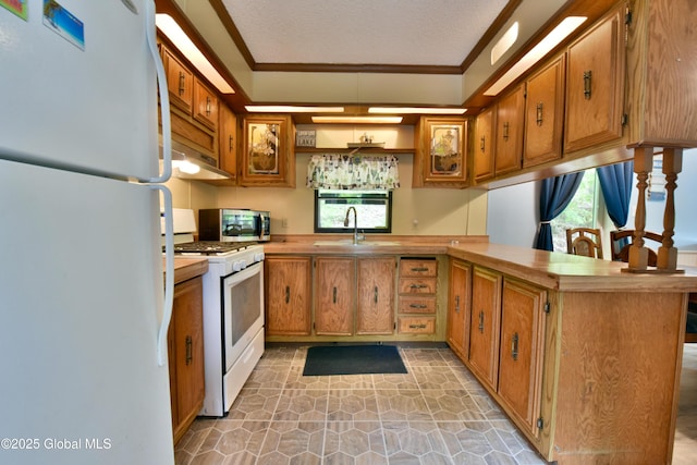 202 Lakeland Rd, Edinburg, NY 12835 - kitchen featuring white appliances, a sink, ornamental molding, a peninsula, and brown cabinets