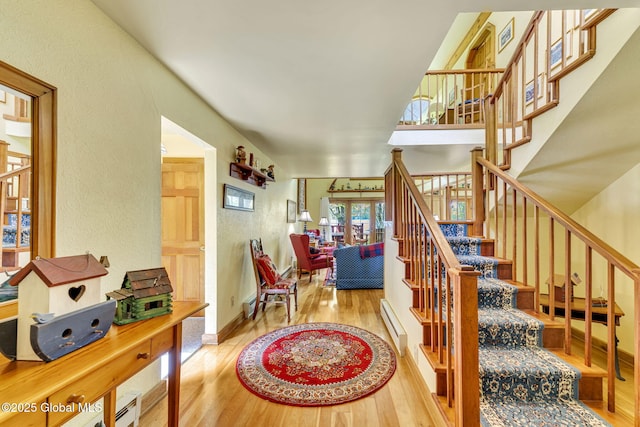 2555 County Highway 22, Exeter, NY 13315 - staircase with wood finished floors, a baseboard radiator, and a textured wall