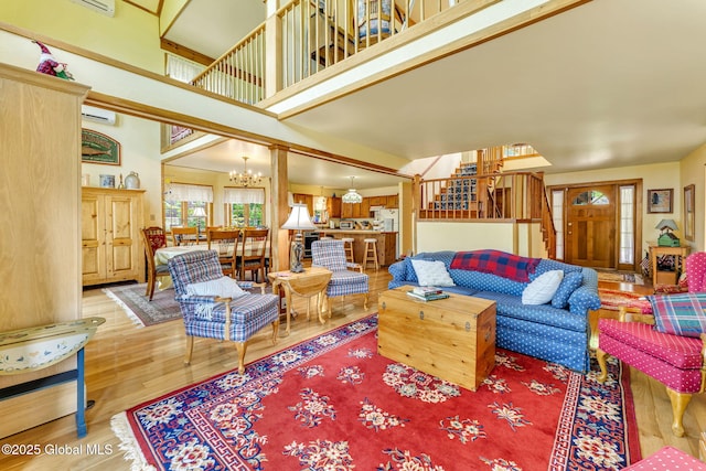 2555 County Highway 22, Exeter, NY 13315 - living room featuring a chandelier, wood finished floors, a high ceiling, stairway, and a wall mounted AC