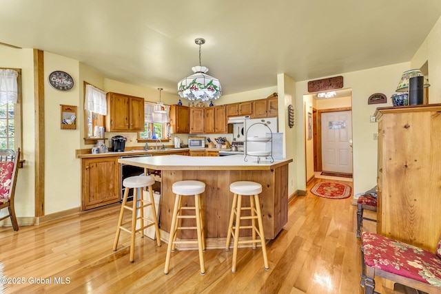 2555 County Highway 22, Exeter, NY 13315 - kitchen featuring dishwashing machine, light wood-type flooring, light countertops, and a kitchen bar
