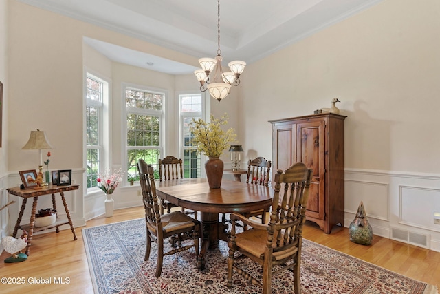 6 Rose Ct, Malta, NY 12019 - dining space with light wood-type flooring, a chandelier, a wainscoted wall, a decorative wall, and crown molding