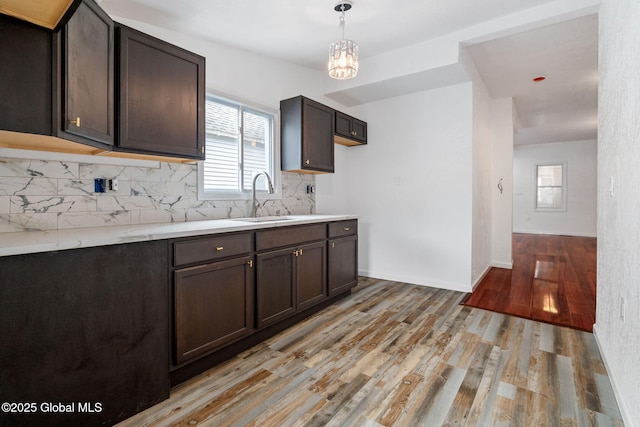 1084 Webster St, Schenectady, NY 12303 - kitchen with a sink, decorative backsplash, dark brown cabinets, light wood-type flooring, and pendant lighting
