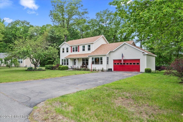 15 Iris Ave, Moreau, NY 12803 - view of front of home with driveway, an attached garage, a front lawn, and covered porch