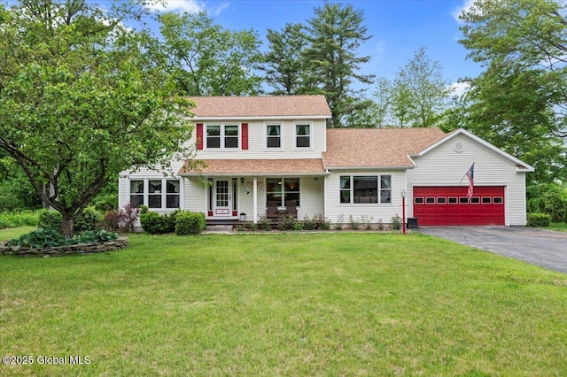15 Iris Ave, Moreau, NY 12803 - traditional-style home featuring driveway, a garage, a front lawn, covered porch, and a shingled roof