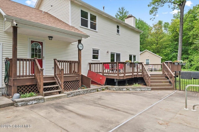 15 Iris Ave, Moreau, NY 12803 - rear view of property featuring a chimney, a deck, a patio, and roof with shingles