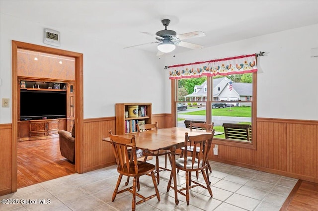 15 Iris Ave, Moreau, NY 12803 - dining space with a wainscoted wall, wood walls, a ceiling fan, and light tile patterned flooring