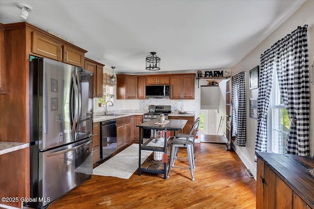 212 County Route 70, Stillwater, NY 12170 - kitchen with stainless steel appliances, a sink, light wood-type flooring, and decorative backsplash