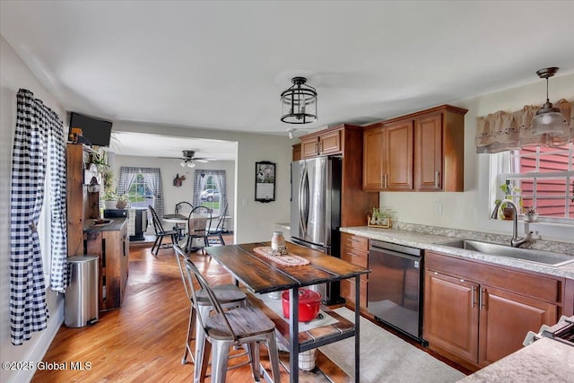 212 County Route 70, Stillwater, NY 12170 - kitchen with stainless steel appliances, a sink, brown cabinets, light wood finished floors, and light countertops