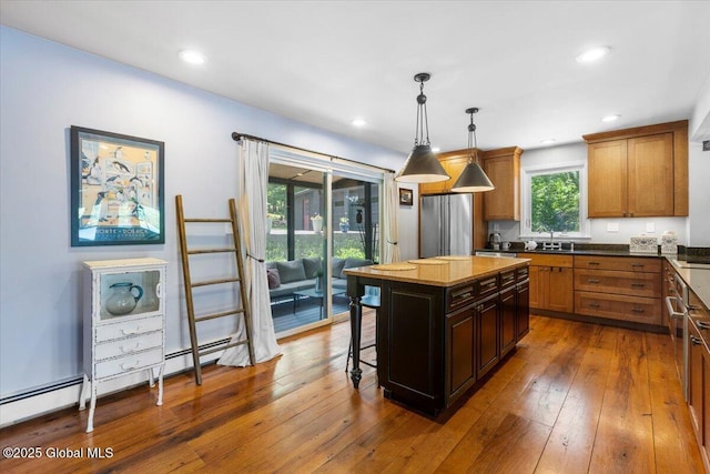 162 Methodist Farm Rd, Sand Lake, NY 12018 - kitchen with a kitchen breakfast bar, hanging light fixtures, wood-type flooring, freestanding refrigerator, and brown cabinets