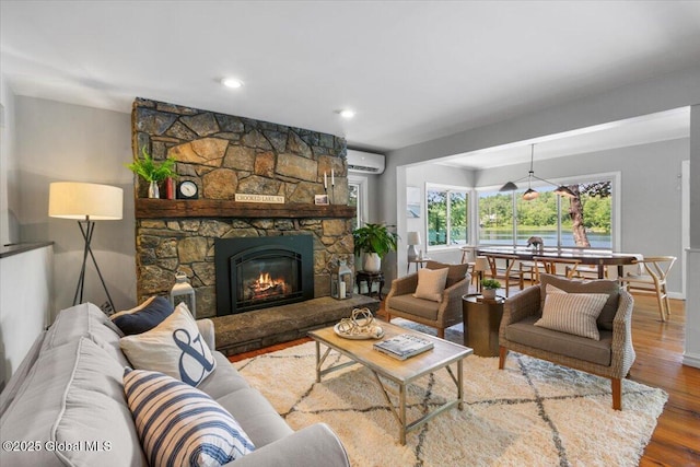162 Methodist Farm Rd, Sand Lake, NY 12018 - living area with wood finished floors, a wall mounted air conditioner, a stone fireplace, and recessed lighting