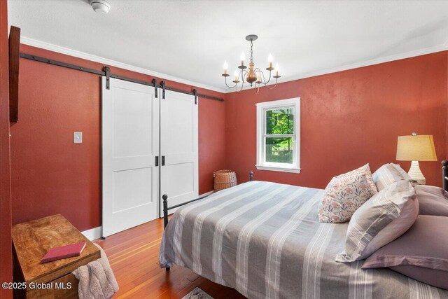 162 Methodist Farm Rd, Sand Lake, NY 12018 - bedroom with a barn door, wood finished floors, a chandelier, and crown molding