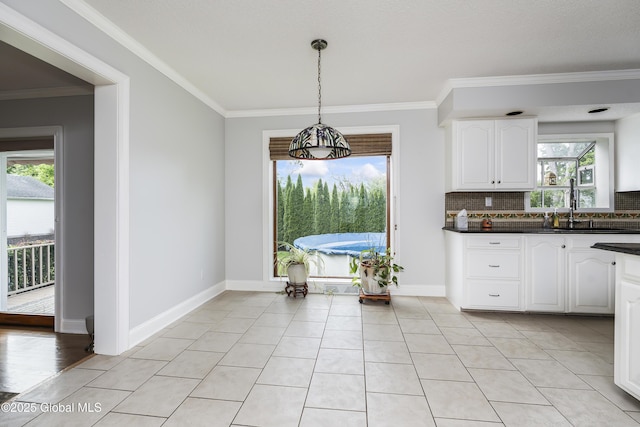 987 Grooms Rd, Rexford, NY 12148 - kitchen featuring dark countertops, white cabinets, tasteful backsplash, a sink, and crown molding