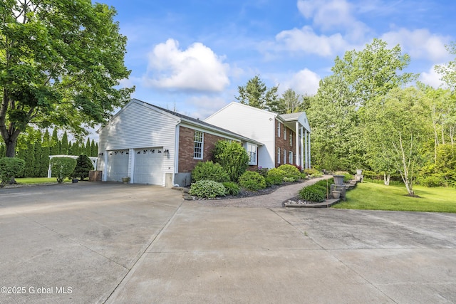 987 Grooms Rd, Rexford, NY 12148 - view of side of home featuring brick siding, concrete driveway, an attached garage, and a yard