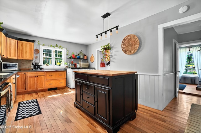 784 Ny Highway 351, Poestenkill, NY 12140 - kitchen featuring butcher block countertops, radiator heating unit, light wood finished floors, stainless steel microwave, and wainscoting