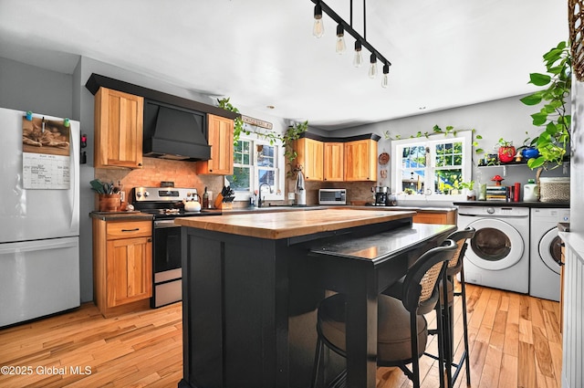 784 Ny Highway 351, Poestenkill, NY 12140 - kitchen featuring custom range hood, freestanding refrigerator, independent washer and dryer, butcher block countertops, and stainless steel electric range