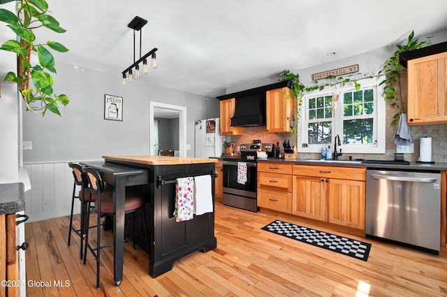 784 Ny Highway 351, Poestenkill, NY 12140 - kitchen with stainless steel appliances, a sink, light wood finished floors, decorative backsplash, and wainscoting