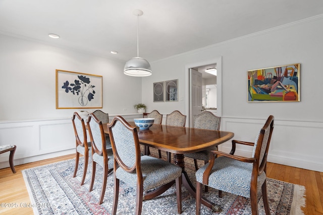 20 Darroch Rd, Bethlehem, NY 12054 - dining room featuring crown molding, a decorative wall, wainscoting, and light wood-style floors