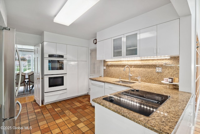 20 Darroch Rd, Bethlehem, NY 12054 - kitchen with a warming drawer, white appliances, decorative backsplash, white cabinetry, and glass insert cabinets