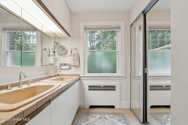 20 Darroch Rd, Bethlehem, NY 12054 - bathroom featuring radiator and double vanity