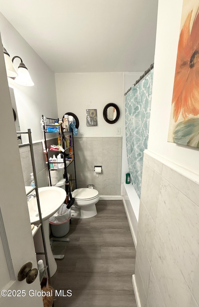 51 Coleman Ave, Hudson Falls, NY 12839 - bathroom with tile walls, toilet, wood finished floors, a wainscoted wall, and shower / tub combo with curtain