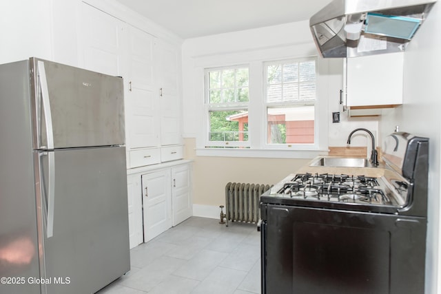 210 N Ballston Ave, Scotia, NY 12302 - kitchen with freestanding refrigerator, radiator, gas stove, a sink, and wall chimney range hood