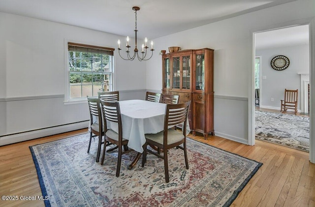 14 Woodridge Rd, Bethlehem, NY 12054 - dining space featuring a chandelier, a baseboard radiator, and light wood-style flooring