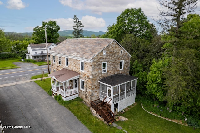 98 George St, Fort Ann, NY 12827 - view of property exterior featuring covered porch, stone siding, a sunroom, a high end roof, and a lawn