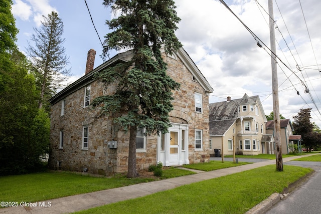 98 George St, Fort Ann, NY 12827 - view of front of property featuring stone siding, a chimney, and a front lawn