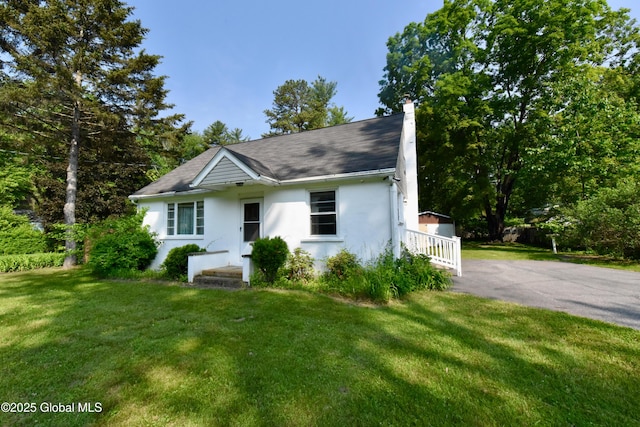 102 Willow St, Guilderland, NY 12084 - view of front of property with stucco siding, a chimney, and a front lawn