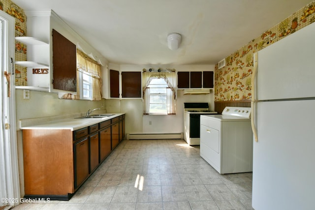 102 Willow St, Guilderland, NY 12084 - kitchen with washer / dryer, white appliances, baseboard heating, a sink, and light countertops
