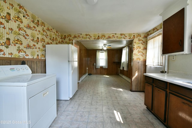 102 Willow St, Guilderland, NY 12084 - kitchen with washer / clothes dryer, freestanding refrigerator, wallpapered walls, light countertops, and wood walls