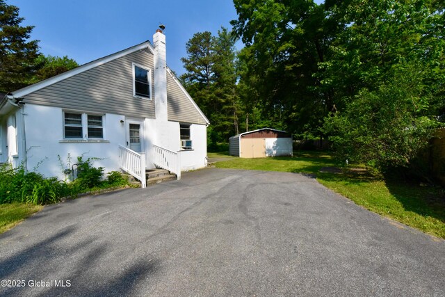 102 Willow St, Guilderland, NY 12084 - view of front of property featuring a chimney, stucco siding, and driveway