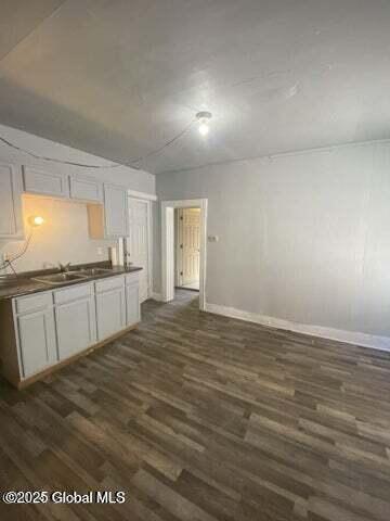 225 Main St, Fort Plain, NY 13339 - kitchen with dark countertops, a sink, dark wood-style flooring, and baseboards
